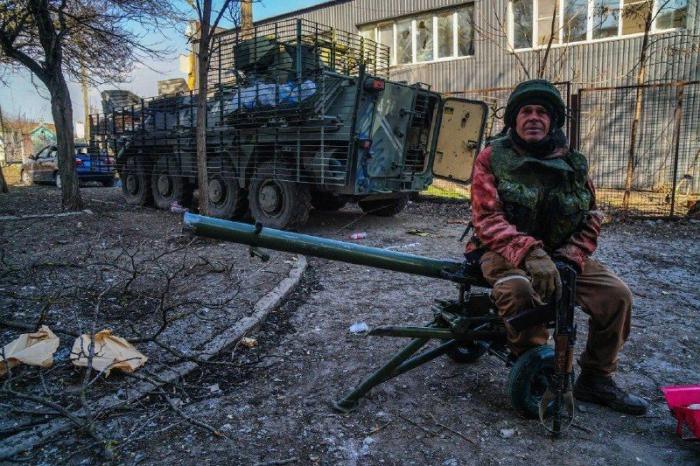 На заглавном фото: боец ДНР в Мариуполе. На заднем плане – брошенная БТР-4 морпехов ВСУ