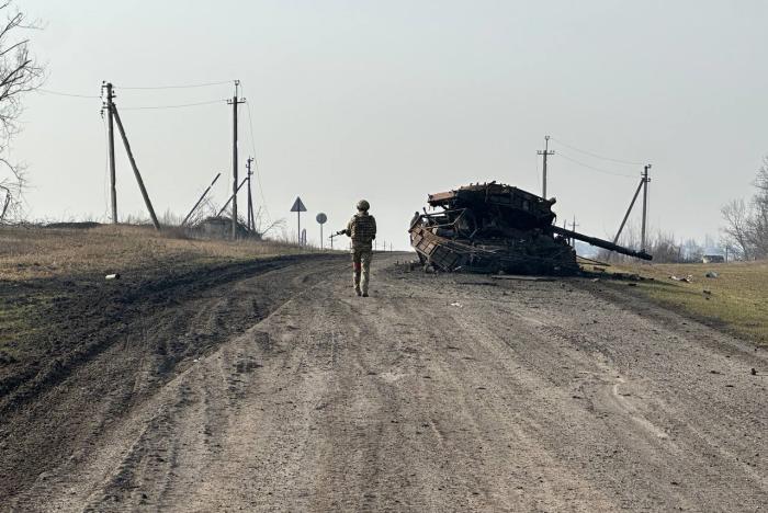 военнослужащий ВС РФ на фоне уничтоженного танка Т-64БВ ВСУ в районе освобождённой Малой Локни