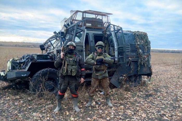 бойцы ВС РФ на фоне подбитого бронеавтомобиля «Козак-2М1», источник Телеграм-канал Военный Осведомитель